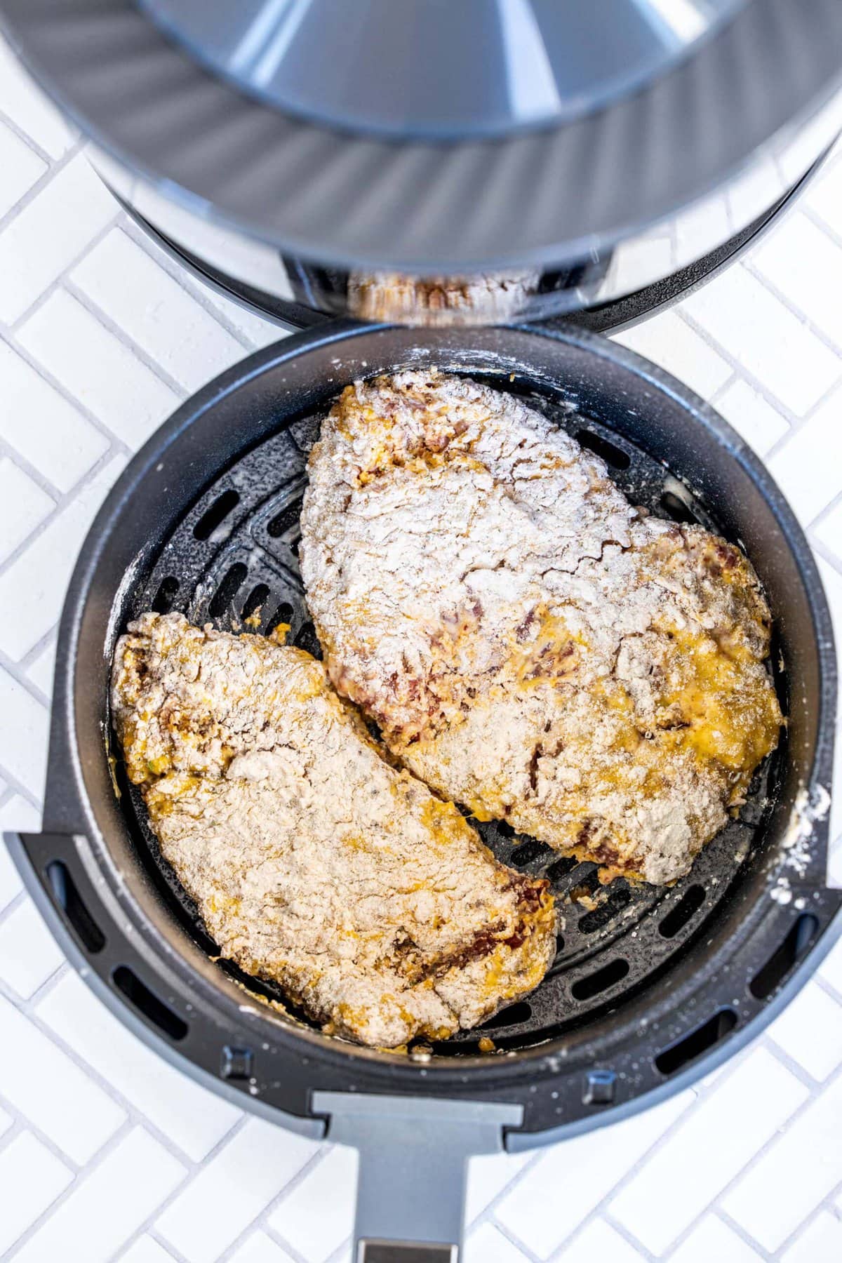 picture of breaded cube steak in air fryer basket