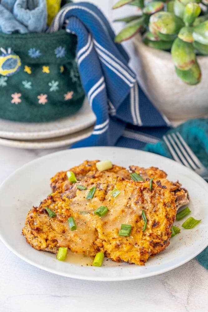 A plate of mashed potatoes with gravy topped by an air-fried chicken fried steak.