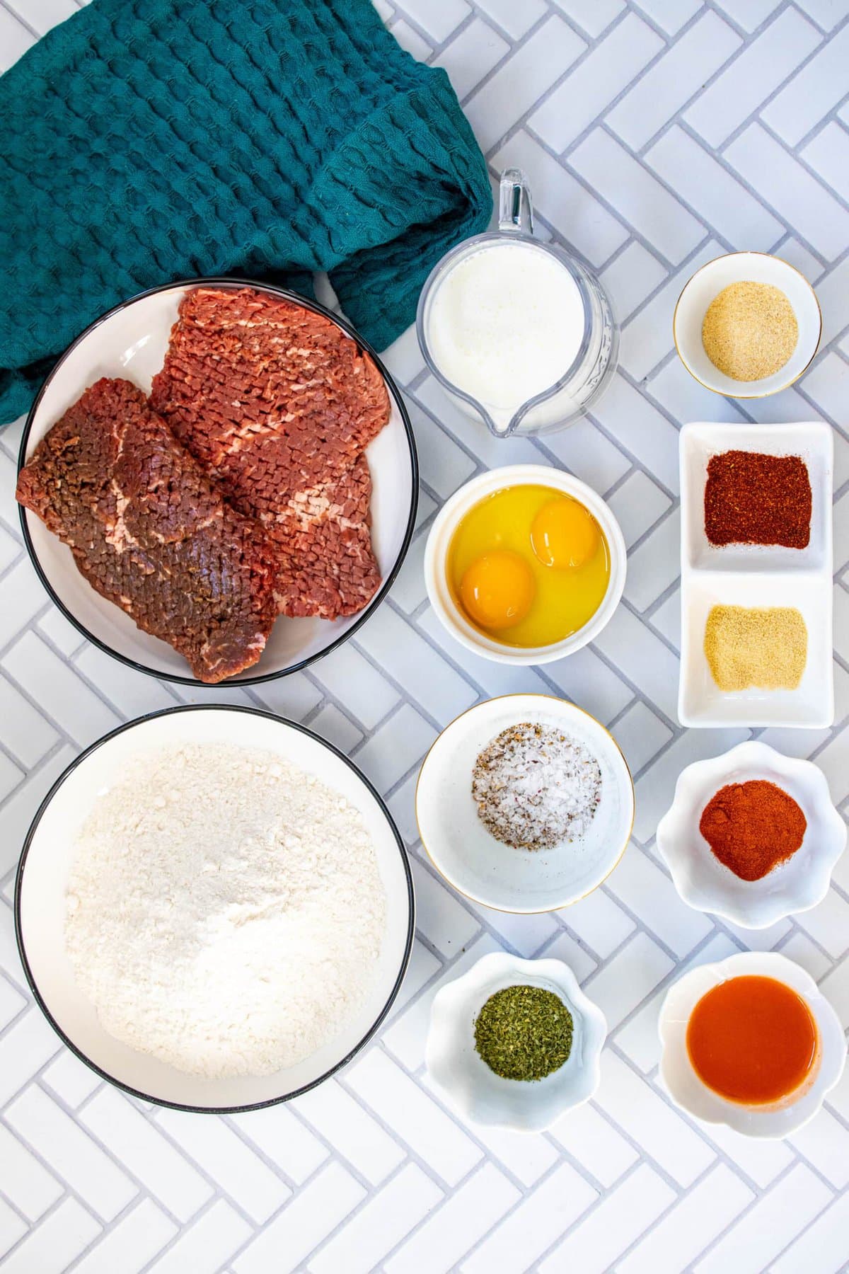 picture of cube steak, flour, herbs, spices, egg on a table