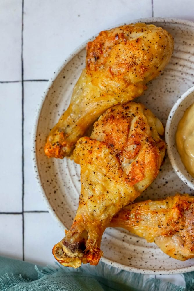 An easy and delicious recipe for air fried chicken drumsticks served with a bowl of dipping sauce.