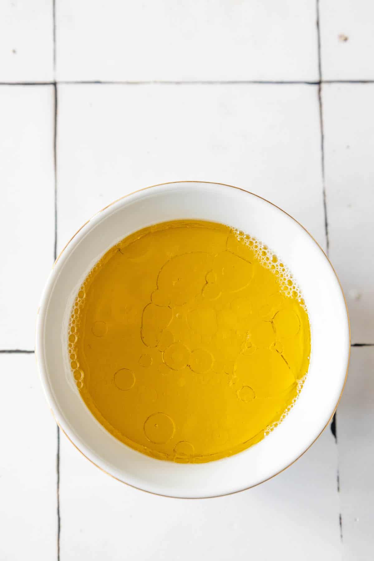 Baked Ranch Chicken Thighs served with olive oil on a white bowl.