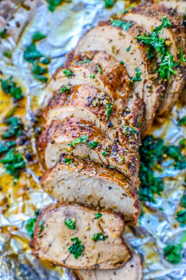 Easy baked pork tenderloin recipe with herbs on top, wrapped in foil.