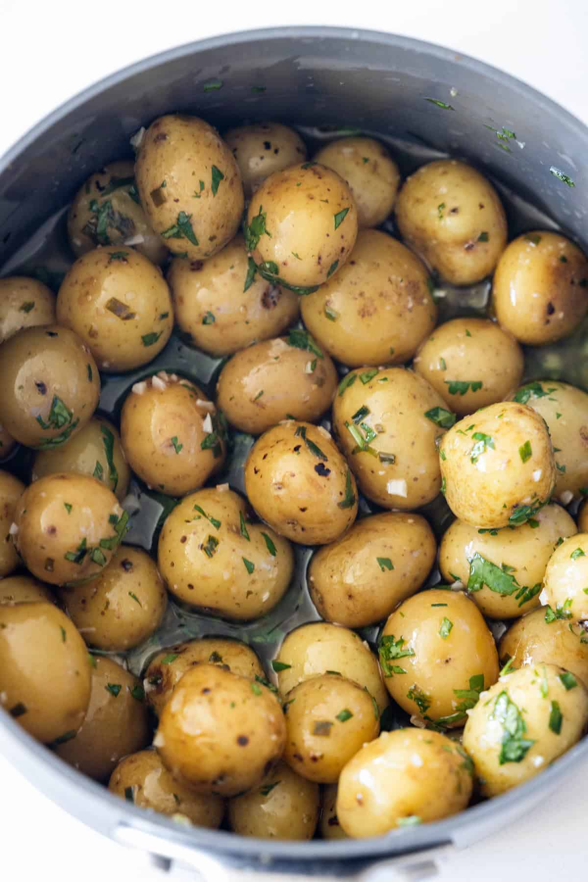 Boiled baby potatoes coated with chopped herbs and seasoning, these garlic and chive potatoes are full of fresh flavor in every bite.