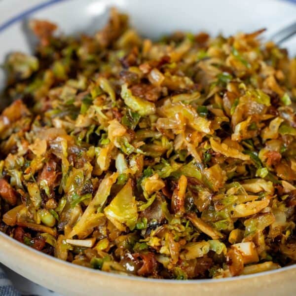 A close-up of a bowl filled with Brussels Sprouts Hash, featuring sautรฉed and shredded Brussels sprouts mixed with browned, crispy bits.