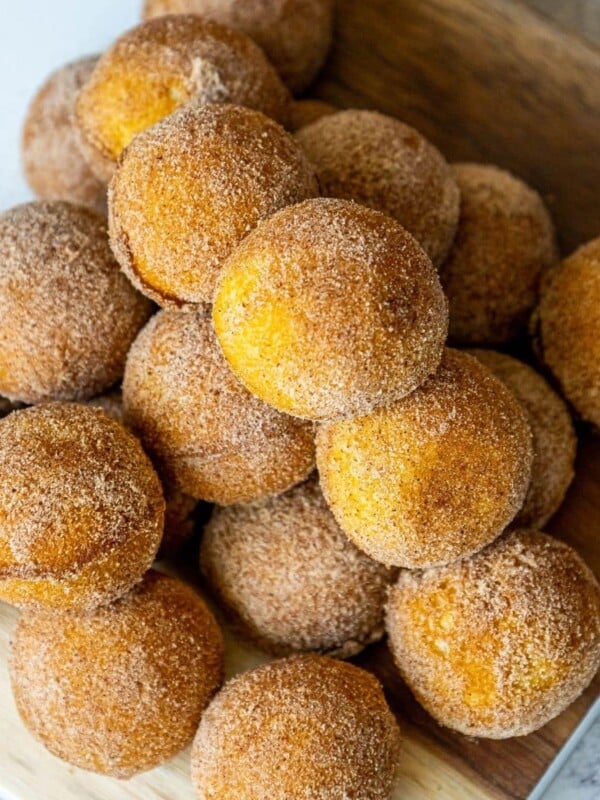 picture of donut holes rubbed in cinnamon sugar stacked on a cutting board