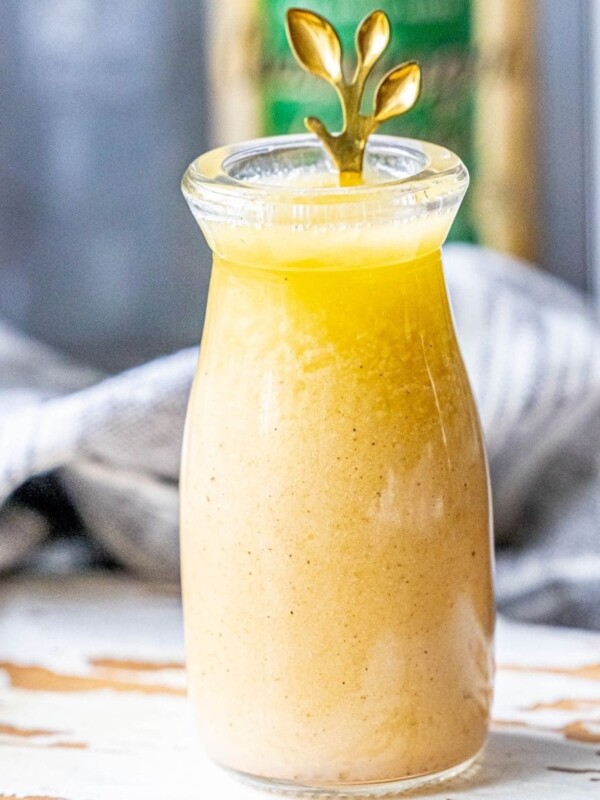 picture of champagne vinaigrette in a bottle with a gold spoon in it