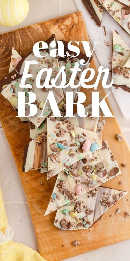 picture of white chocolate and chocolate layered easter bark with cadbury mini eggs on a wood cutting board