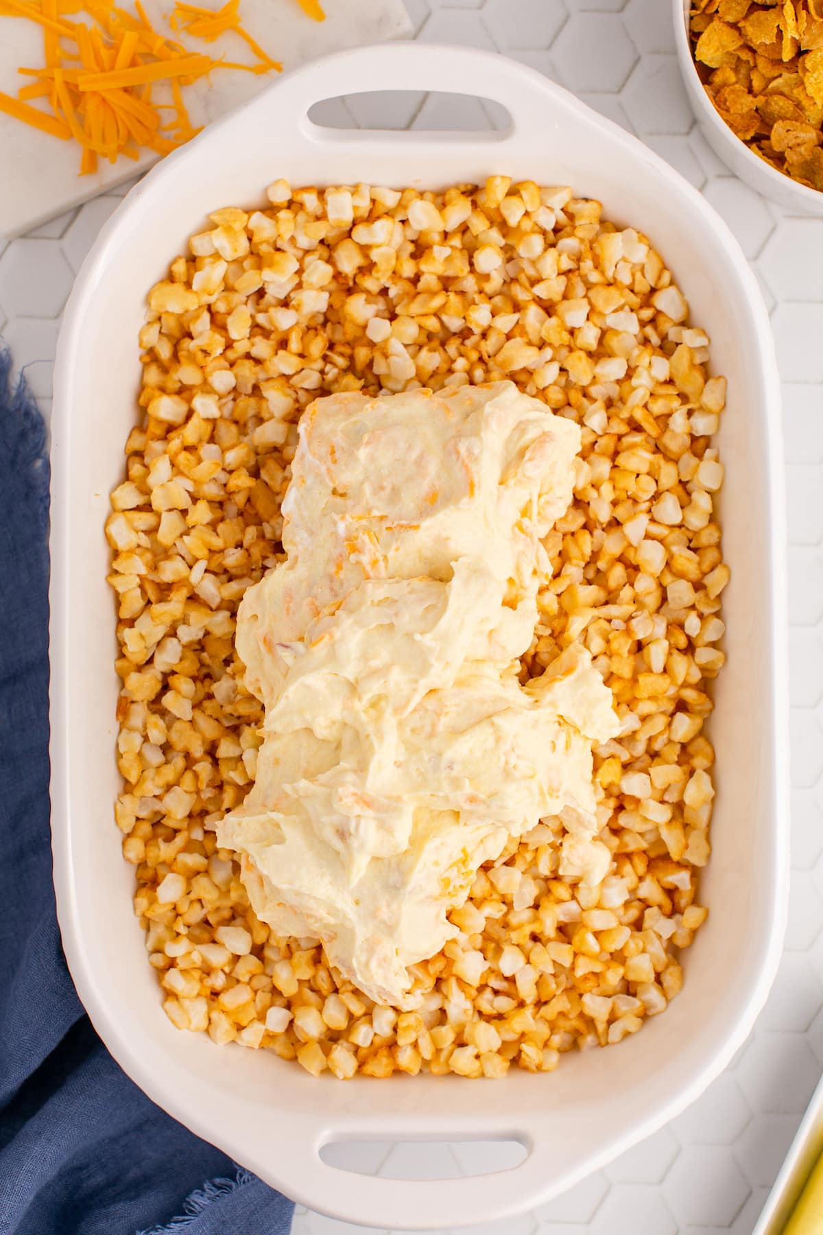 soup and butter mixture spooned over frozen potatoes in a casserole dish