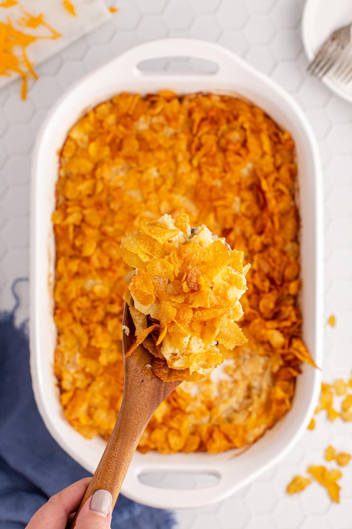 A person enjoying a spoonful of crunchy cheesy tater tot casserole.