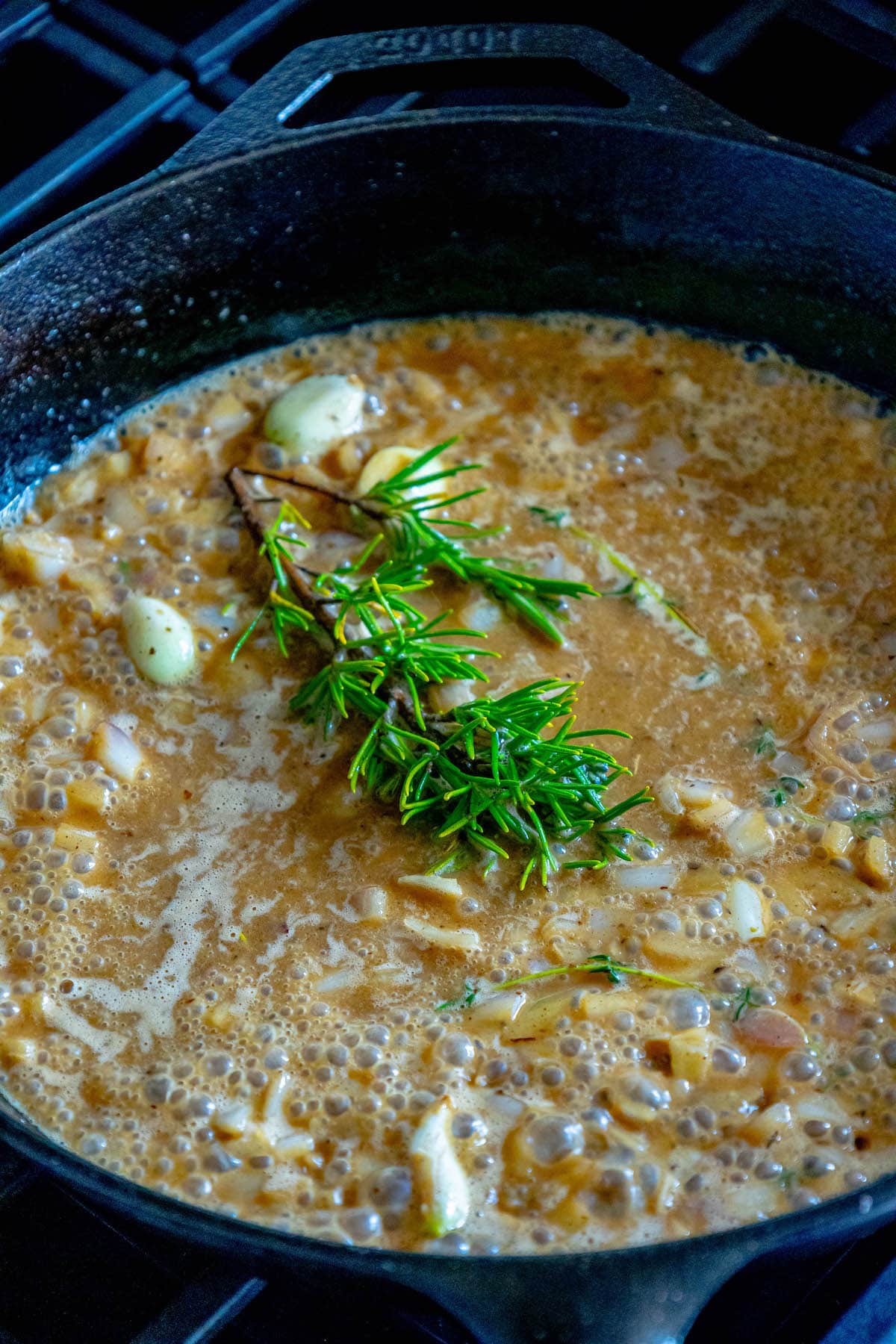white wine sauce with garlic and rosemary in a cast iron pan