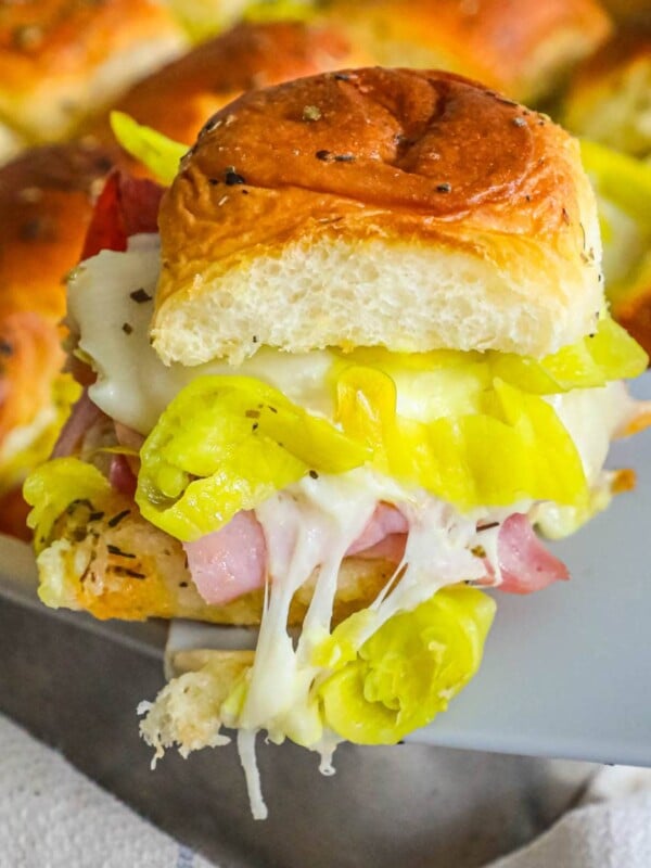 Hot ham and cheese Italian sliders in a pan.