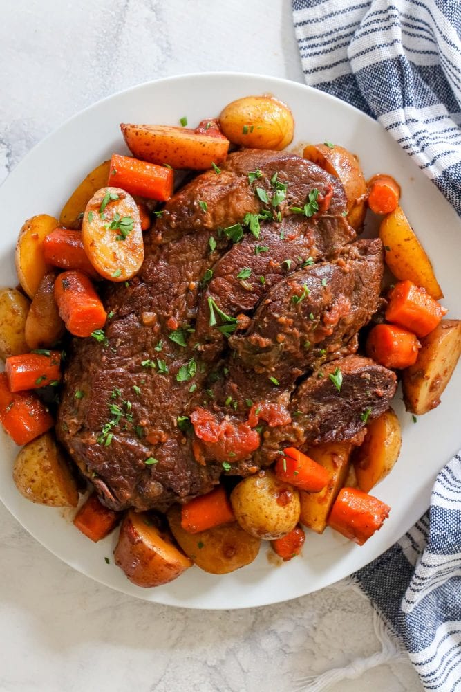 Roast beef with potatoes on a white plate, prepared using the Instant Pot.