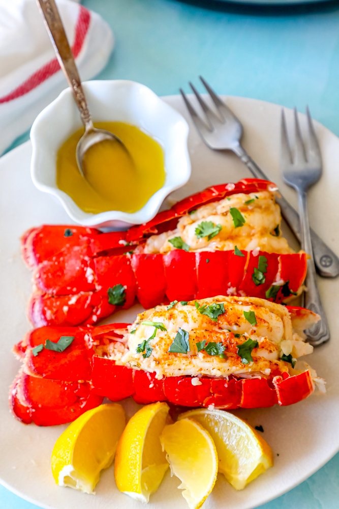 Lobster tails served on a white plate with lemon wedges, prepared using an Instant Pot for an easy and delicious meal.