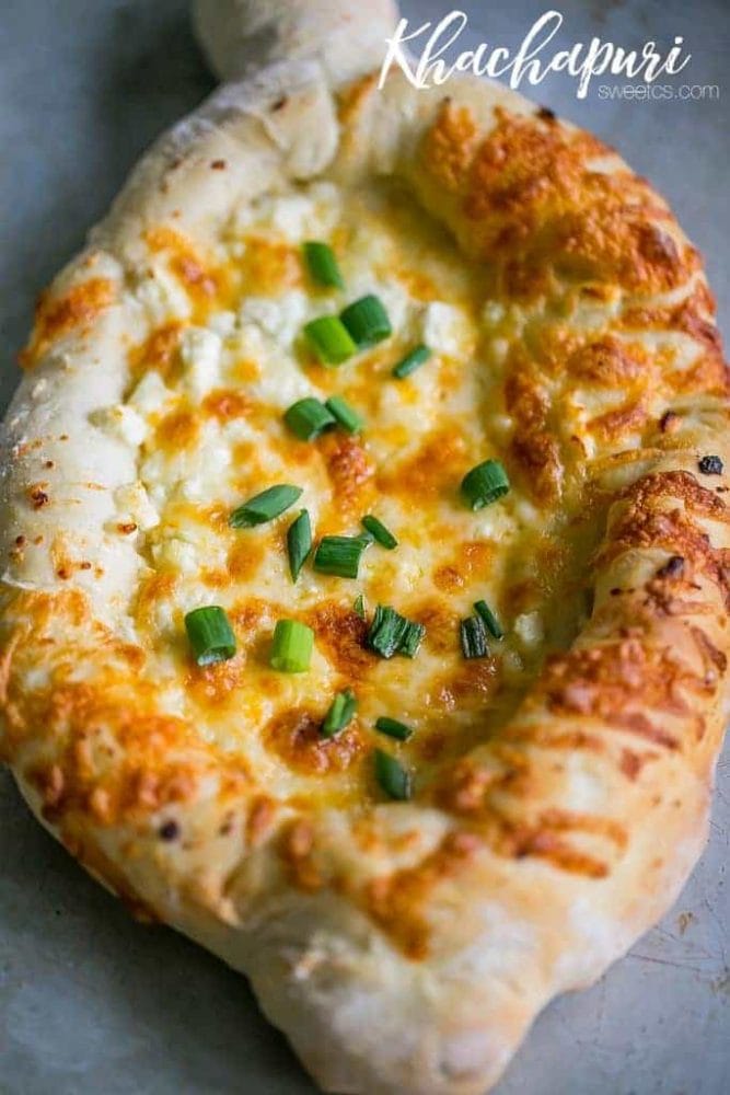 A Khachapuri Georgian Cheese Bread topped with green onions.