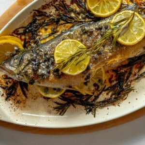 A lemon-branzino dish accompanied by rosemary sprigs.