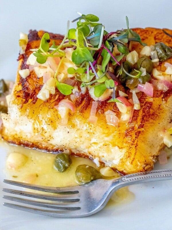 picture of chilean seabass with lemon caper butter on a plate with a fork