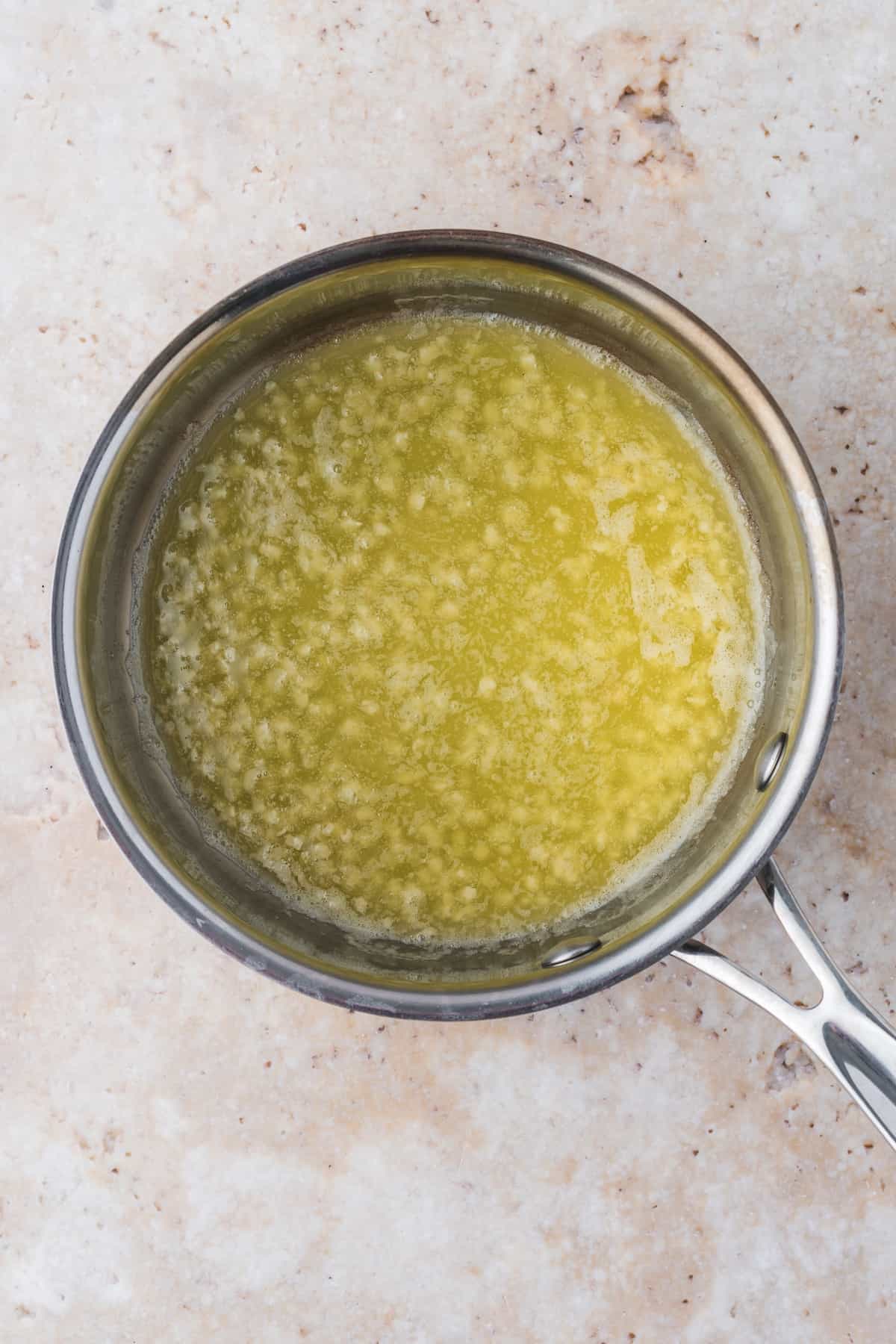 A frying pan with a yellow sauce containing Pan Fried Cod.