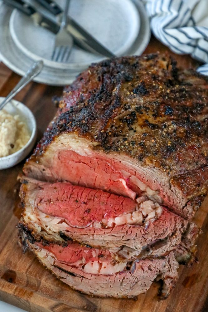 How to make the best prime rib - a sliced roast on a cutting board.