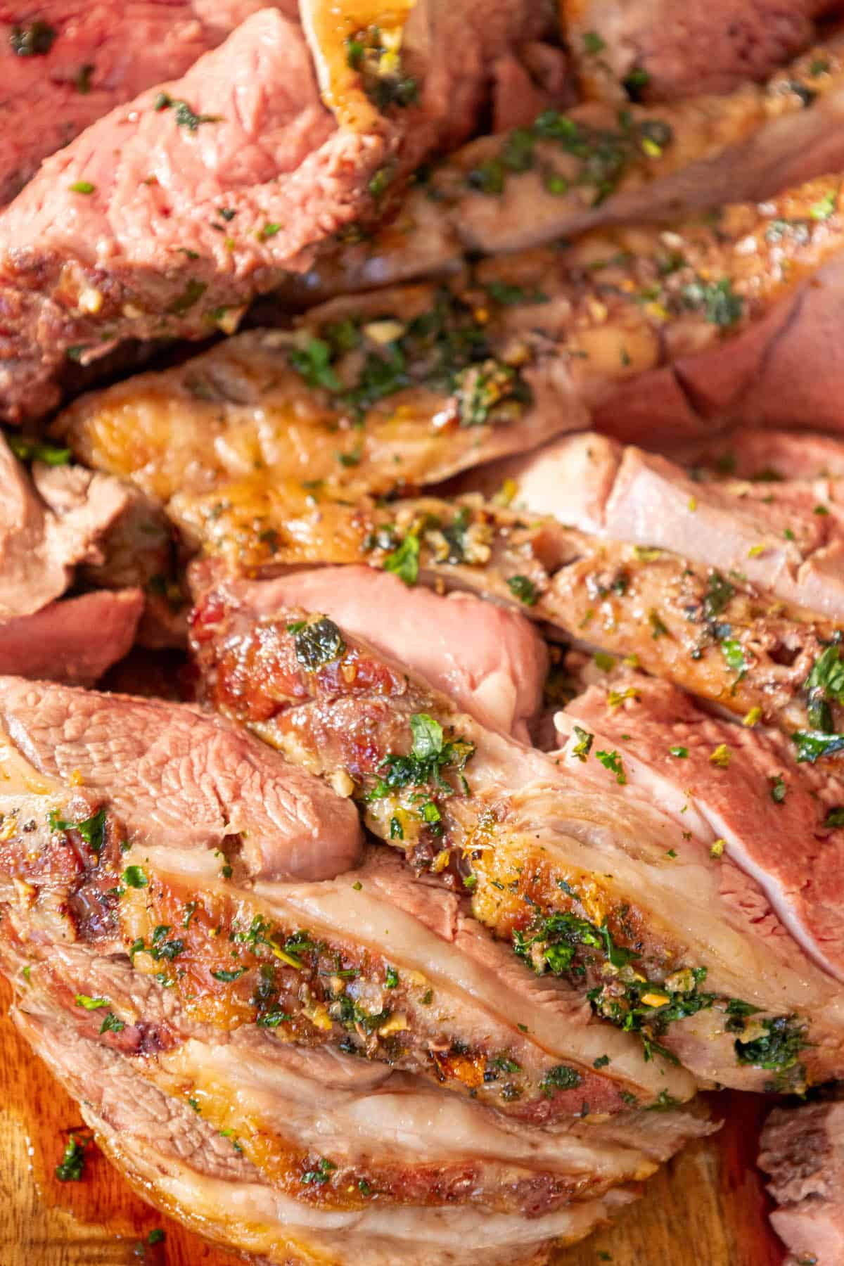 Reverse Seared leg of lamb slices on a wooden cutting board.