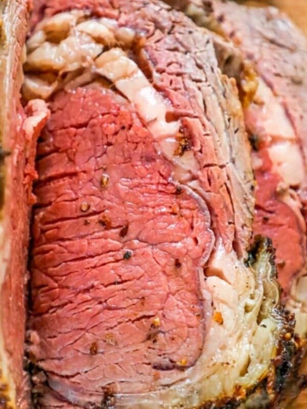 sliced ribeye roast on a wood cutting board