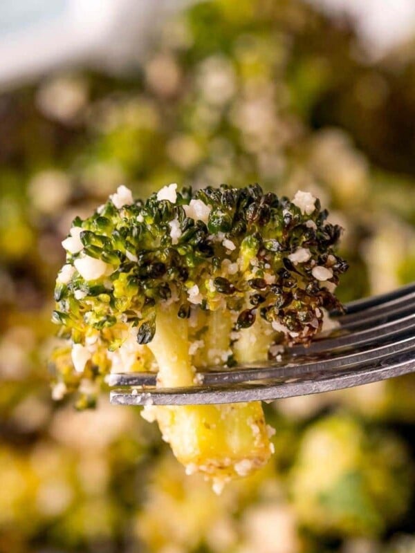 A fork with roasted broccoli on it.