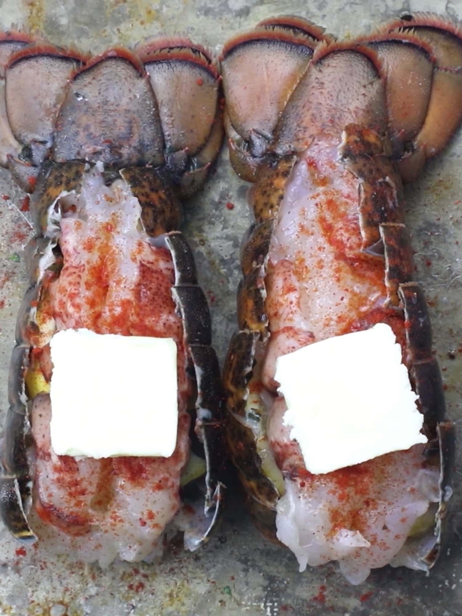 raw lobster tail with paprika and butter on top