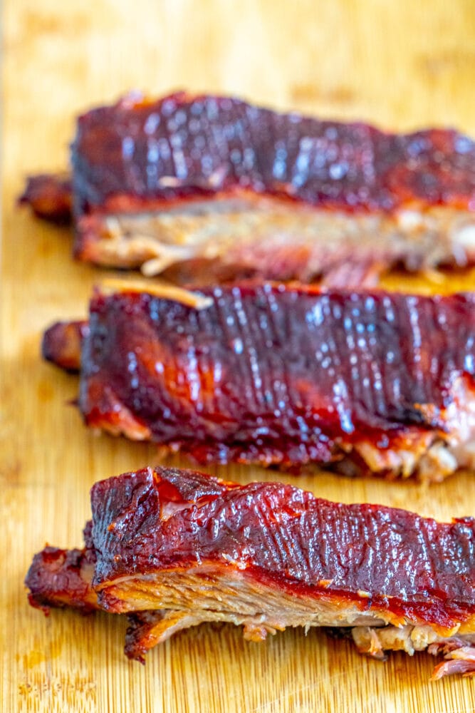 A mouthwatering display of smoked ribs on a rustic wooden cutting board.