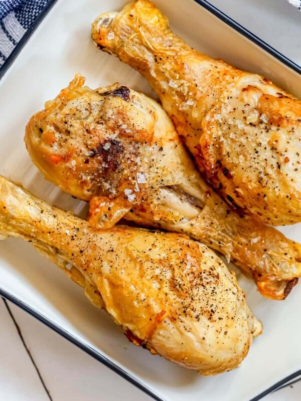 chicken drumsticks in a white dish