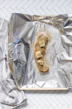 browned pork tenderloin on a piece of foil on a baking sheet