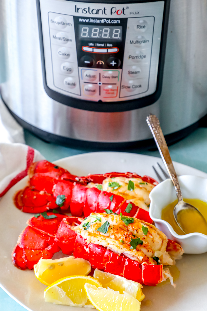 Best Easy Instant Pot Lobster Tail with lemons in front of an instant pot.