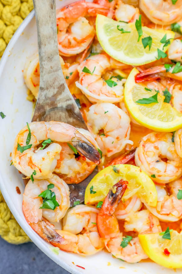 Shrimp cooked in a pan with lemon slices.