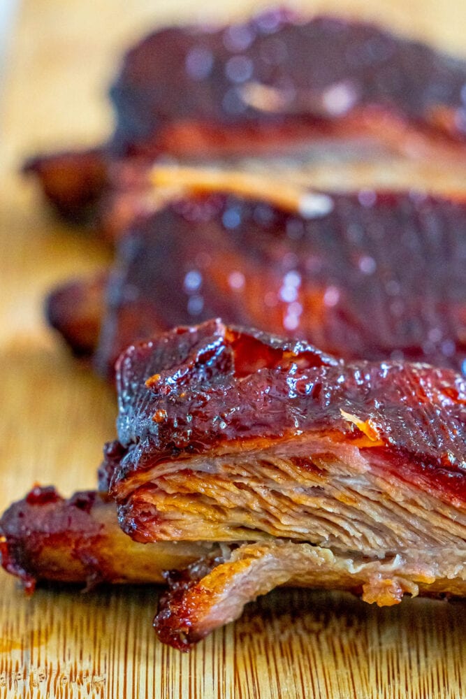 Smoked pork ribs showcased on a wooden cutting board following the 3-2-1 Smoked Ribs method.