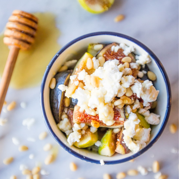 A bowl with figs, nuts and honey, perfect for preparing a delightful fig and honey fruit salad.